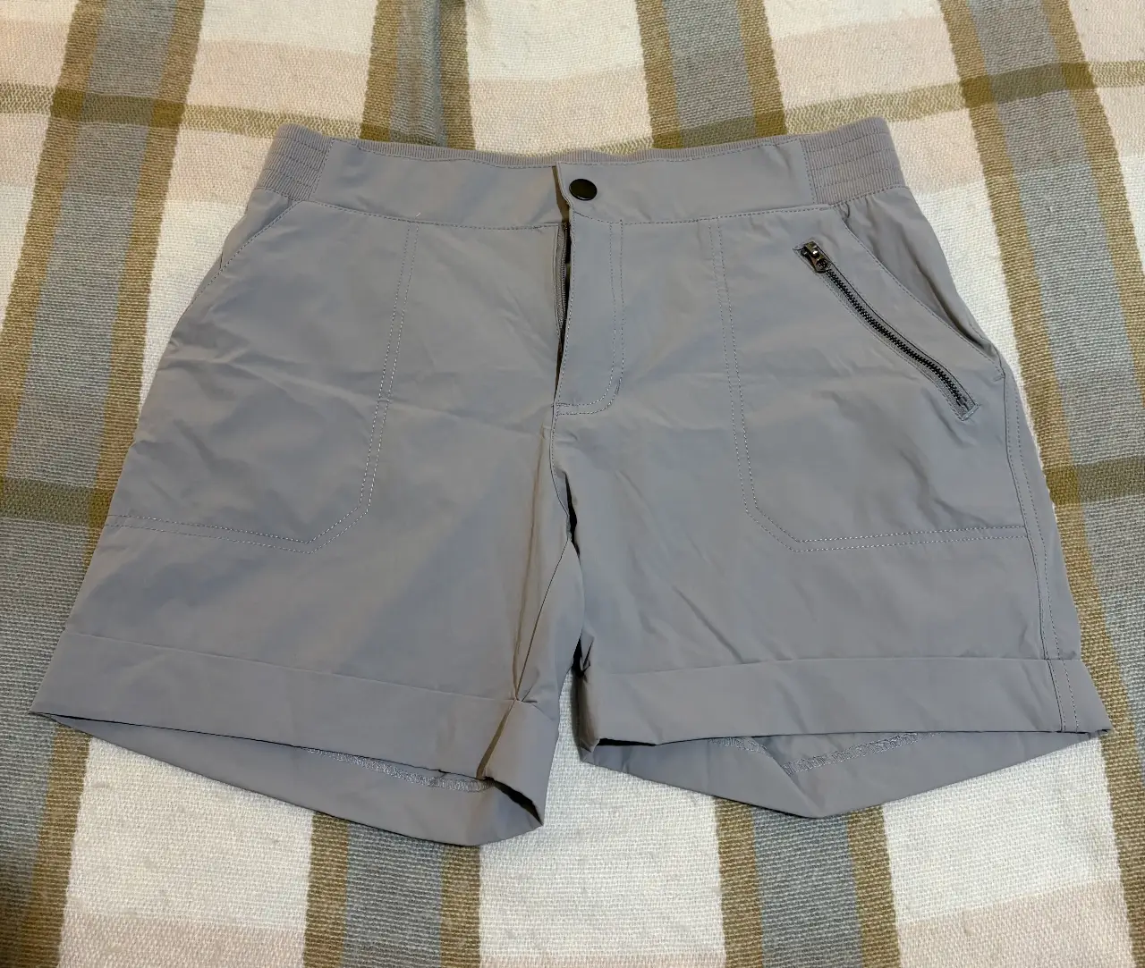 Short deportivo gris para hombre, con bolsillos y cierre. Ideal para actividades al aire libre o uso casual.
