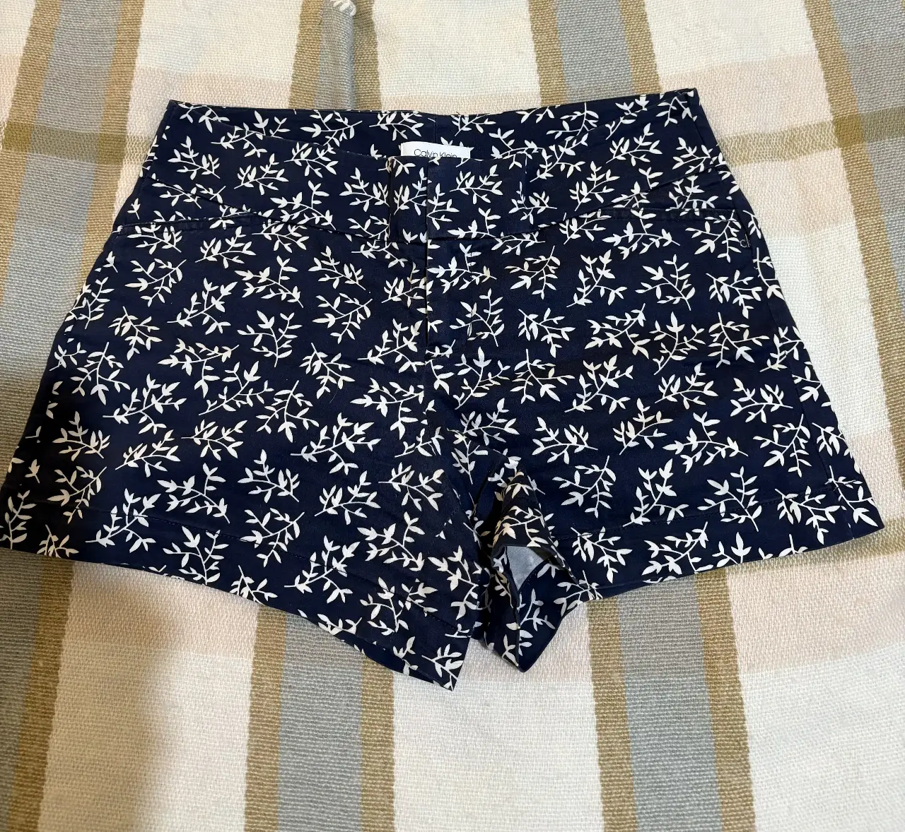 Short de mujer tiro alto con estampado floral en blanco sobre fondo azul marino. Ideal para un look casual y fresco.