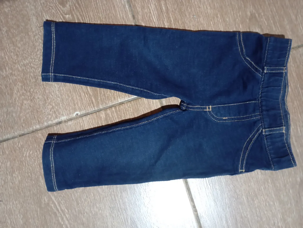 Jean azul para bebé, tiro alto con cintura elastizada y detalles de costura en color ocre. Ideal para el día a día.