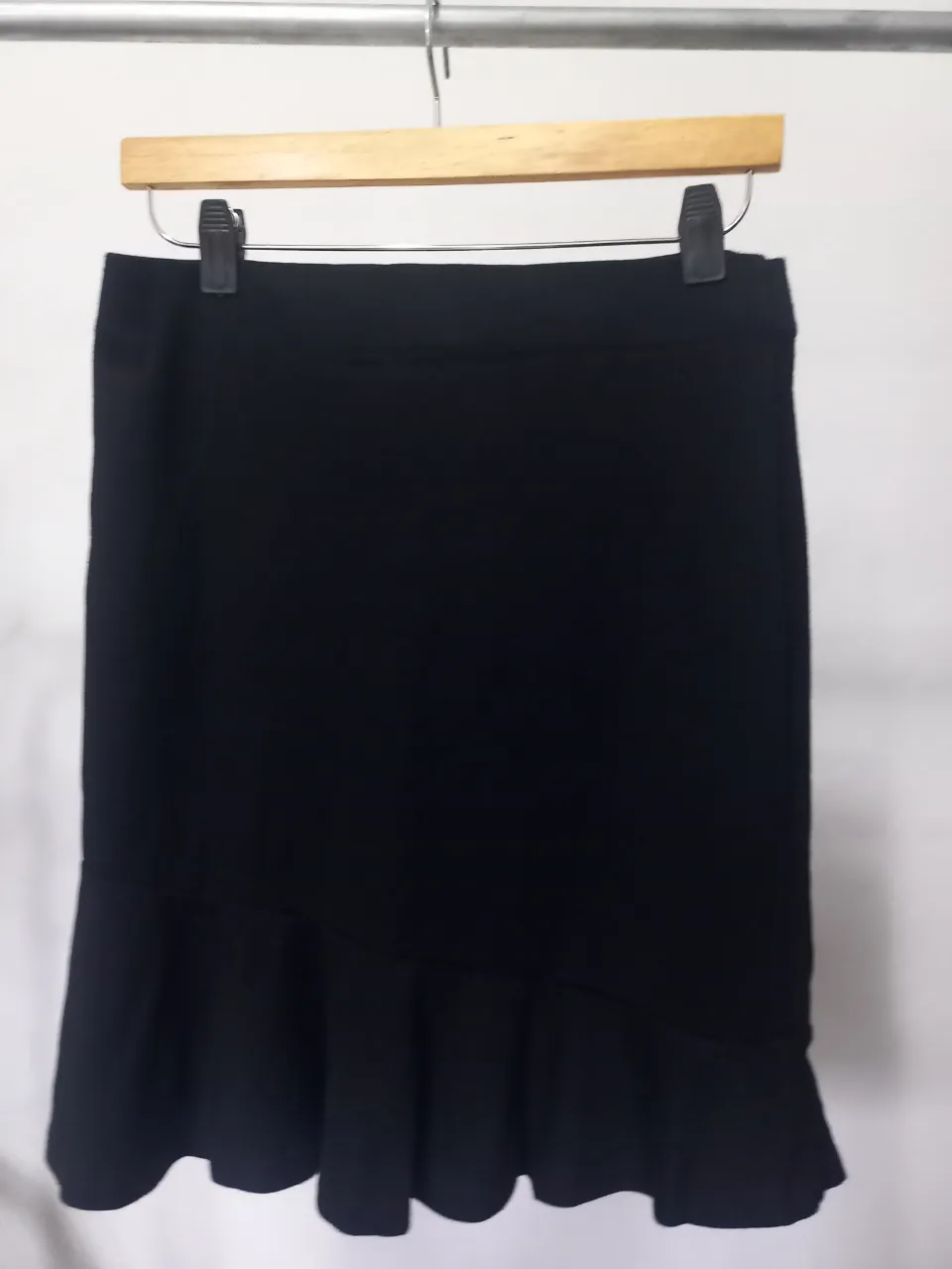 Pollera midi negra de la marca Esprit, con detalle de volado en el ruedo. Ideal para un look elegante y versátil.