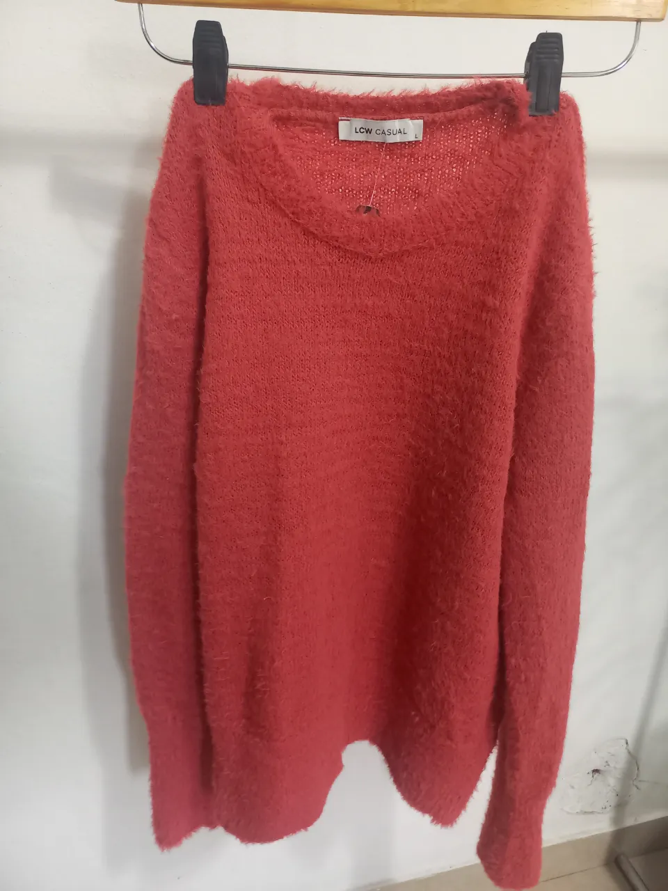 Sweater de tejido suave y abrigado, con cuello en V y un diseño liso. Ideal para un look casual y cómodo en los días fríos.