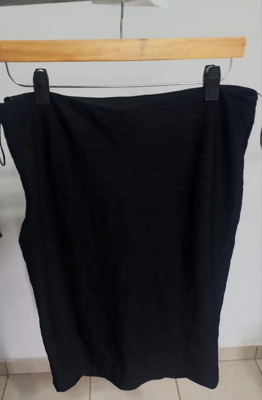 Pollera midi negra de H&M, con cierre lateral y detalle de textura.