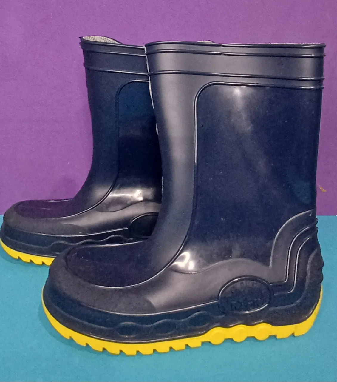 Botas de lluvia de goma azul marino con suela y detalles amarillos.