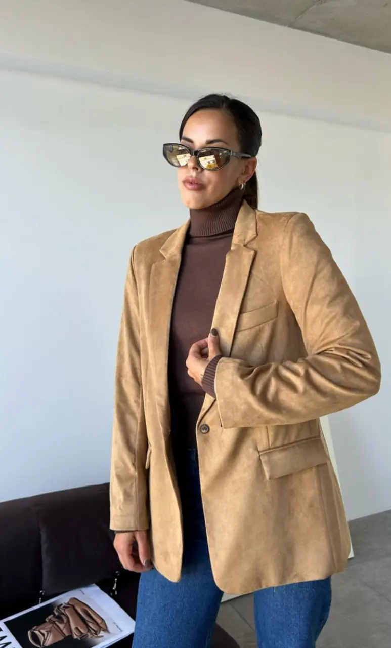 Blazer de gamuza marrón, ideal para un look elegante y sofisticado. Perfecto para combinar con un turtleneck y jeans para un outfit casual chic.