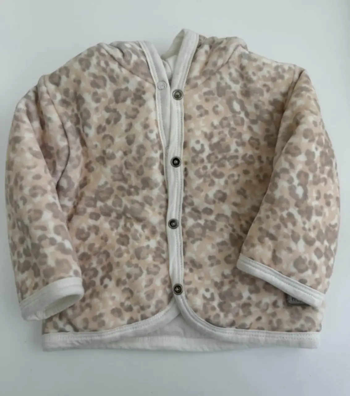 Campera con capucha para bebé, con estampado de leopardo en tonos neutros. Ideal para abrigar con estilo en cualquier ocasión.