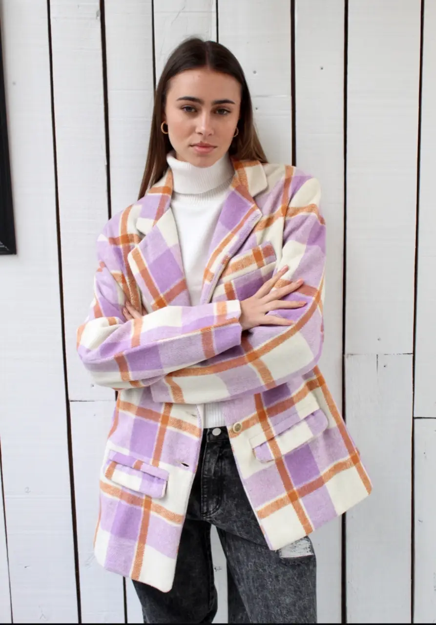 Blazer a cuadros en tonos lila, naranja y blanco. Ideal para un look moderno y canchero. Perfecto para combinar con jeans o pantalones de vestir.
