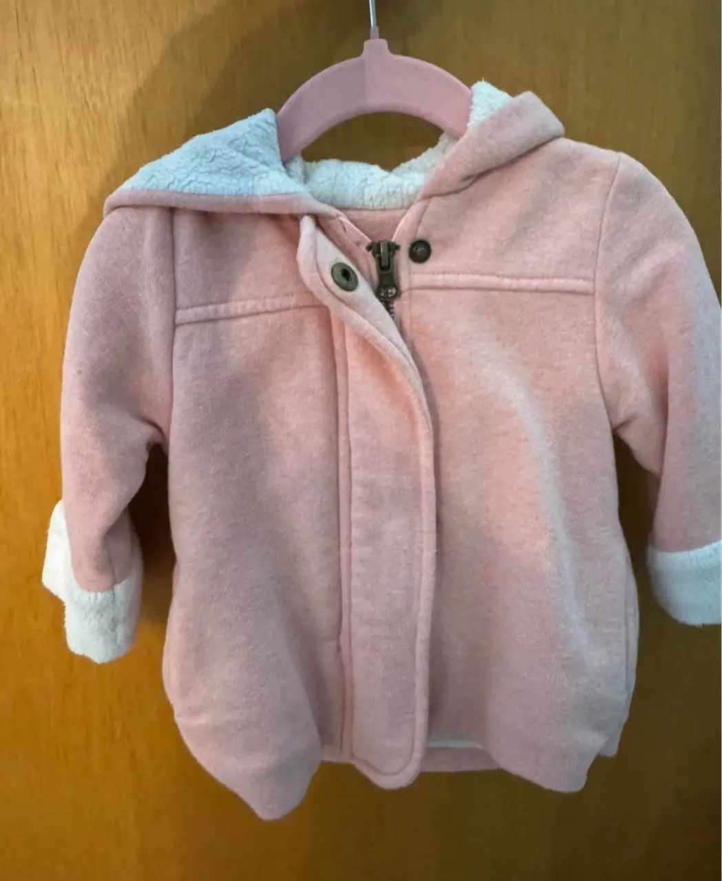 Campera de abrigo para bebé, color rosa con interior de corderito blanco. Ideal para mantener a tu bebé abrigado y cómodo en los días fríos. Cuenta con capucha y cierre frontal.