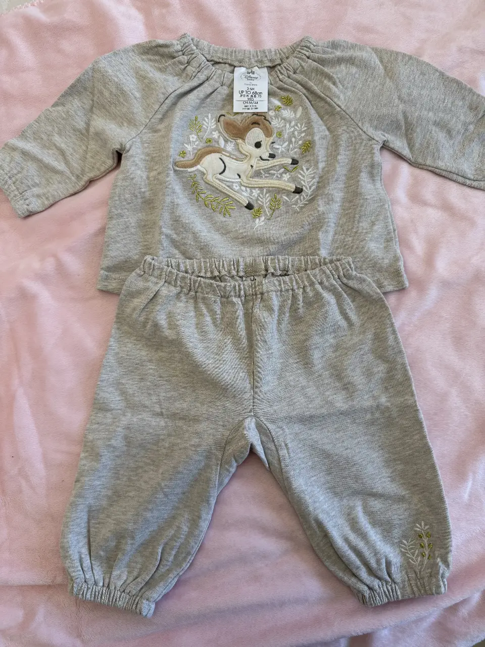 Conjunto de bebé de dos piezas, con un diseño de Bambi bordado en la remera. El conjunto es de color gris, ideal para un look cómodo y tierno.