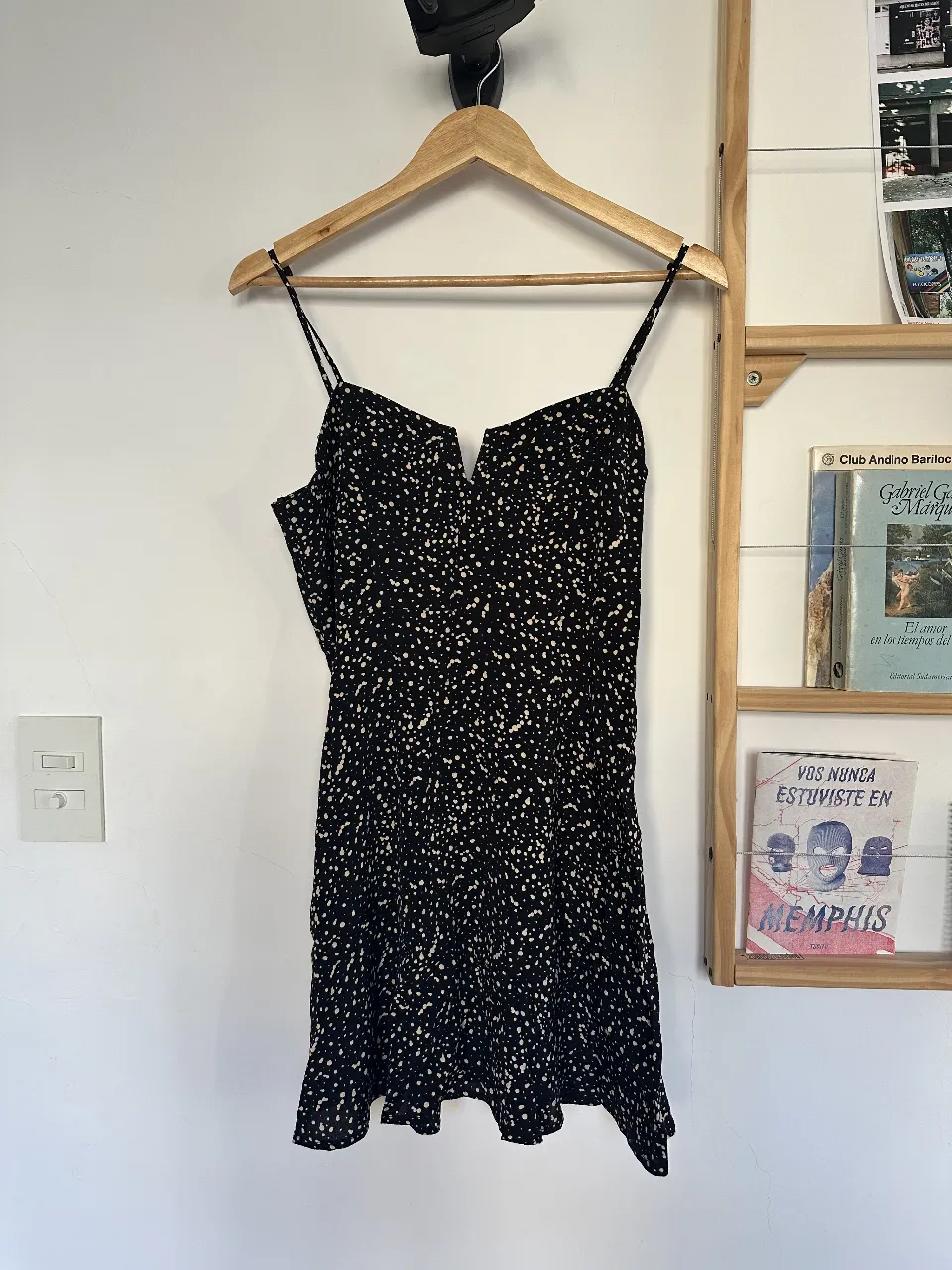 Vestido mini negro con estampado de lunares / manchitas blancas, escote en V (con sosten metalizado por dentro) y tirantes finos regulables. Cierre al costado. Tela de material elegante. 
Sisa: 46 cm
Largo: 68 cm (desde sisa, sin contar tiritas) 