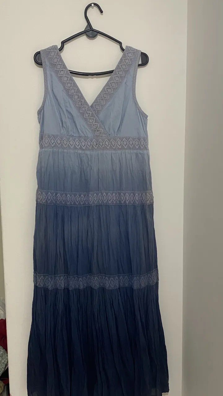 Vestido largo estilo boho, con degradé de tonos azules y detalles de encaje en el escote y la cintura. Ideal para un look relajado y femenino.