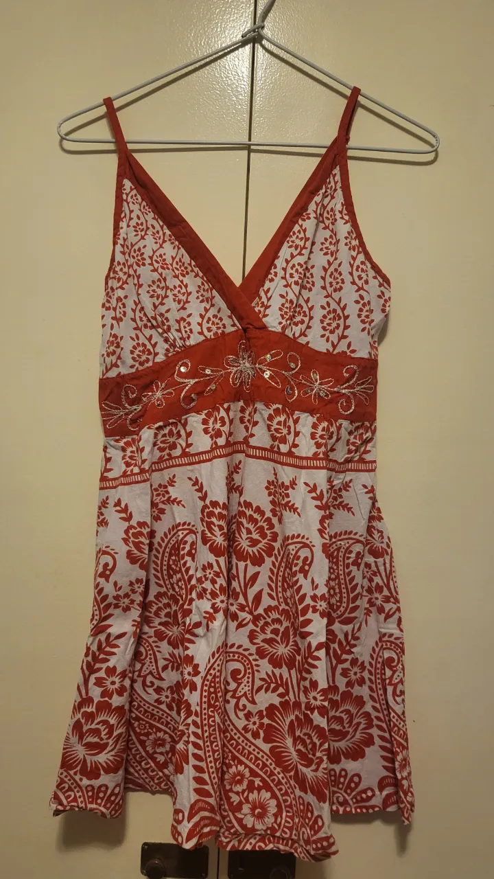 Vestido corto estampado estilo boho, con breteles finos y escote en V. Posee detalles de bordado y elástico en la espalda para un mejor ajuste. Ideal para un look fresco y relajado.