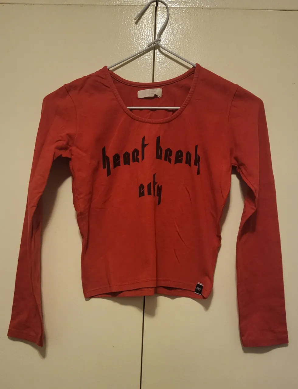 Remera roja manga larga con estampa "heart break city" en negro. Ideal para un look casual y canchero.