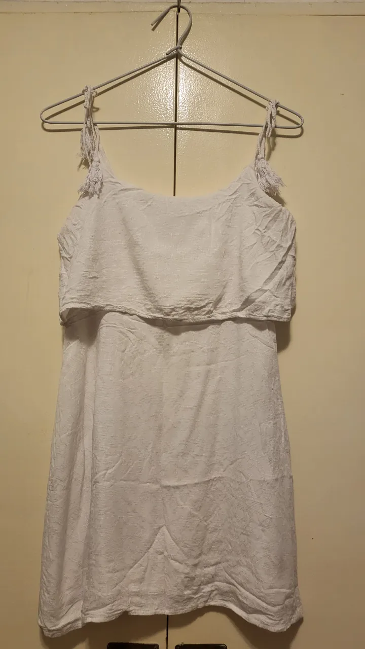 Vestido blanco corto con tiras finas y detalle de volado en el busto. Ideal para un look fresco y veraniego.