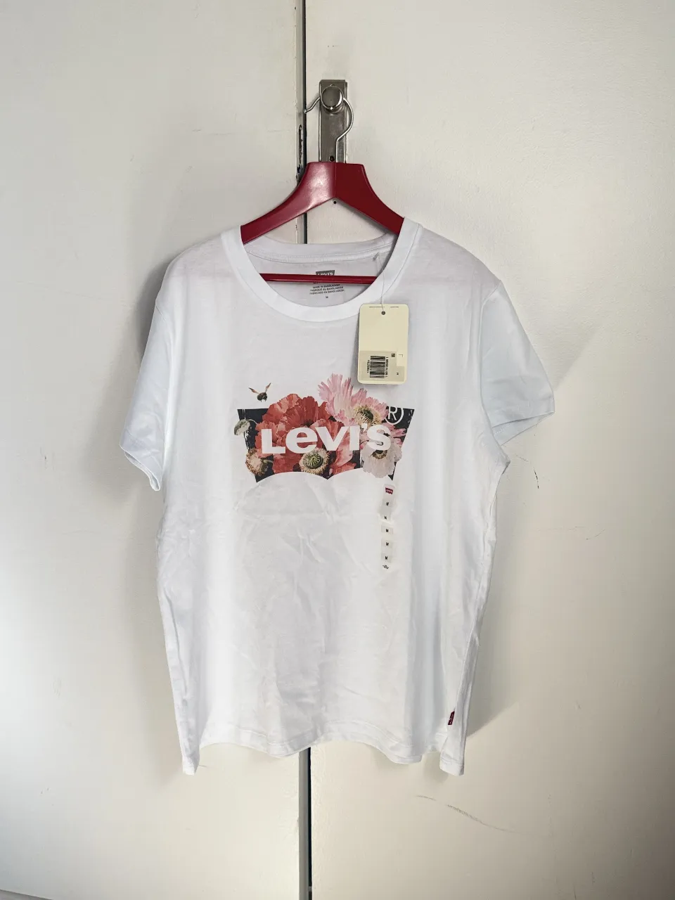 Remera blanca de mujer Levi's con estampado floral en el frente. Talle M, con etiqueta.