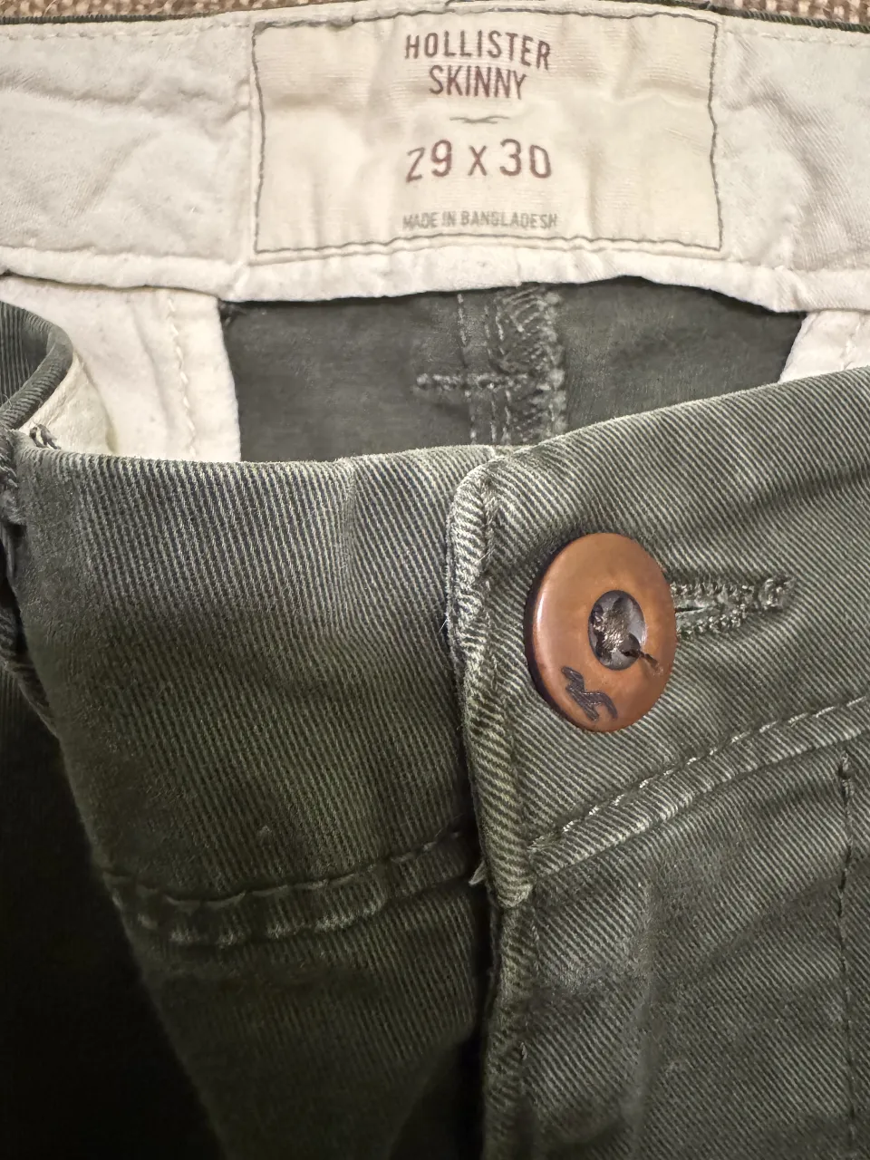 Pantalón chino Hollister Skinny verde oscuro, talle 29x30. Ideal para un look casual y cómodo.