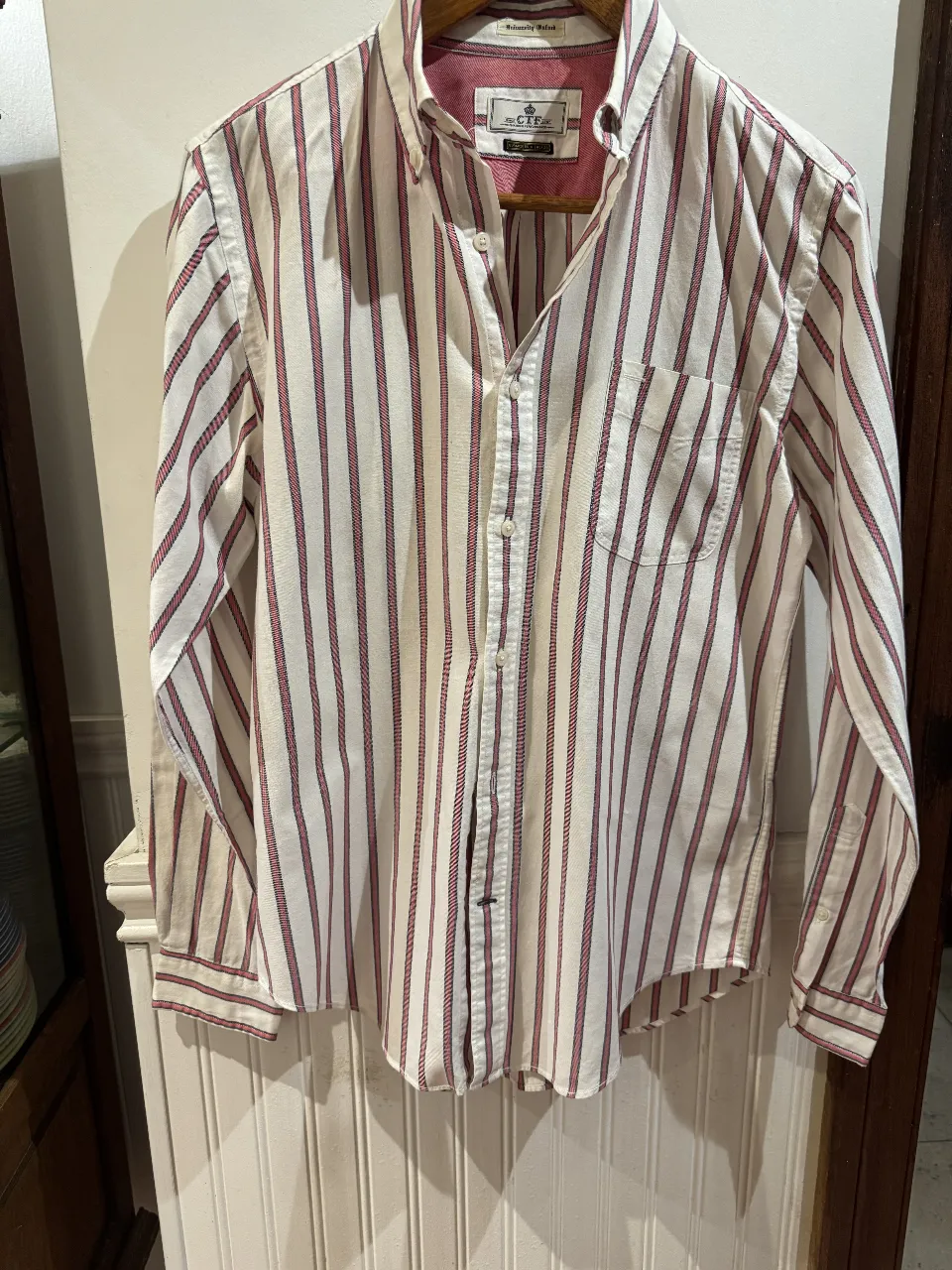 Camisa a rayas verticales en blanco y rojo, de manga larga y corte clásico. Ideal para un look casual y versátil.