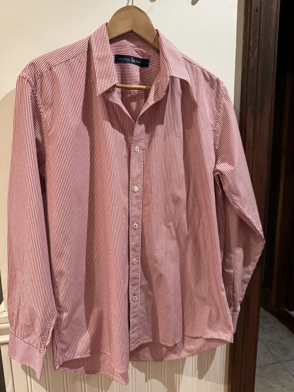 Camisa a rayas rojas y blancas de hombre, manga larga, con cuello y botones. Ideal para un look casual o semi formal.