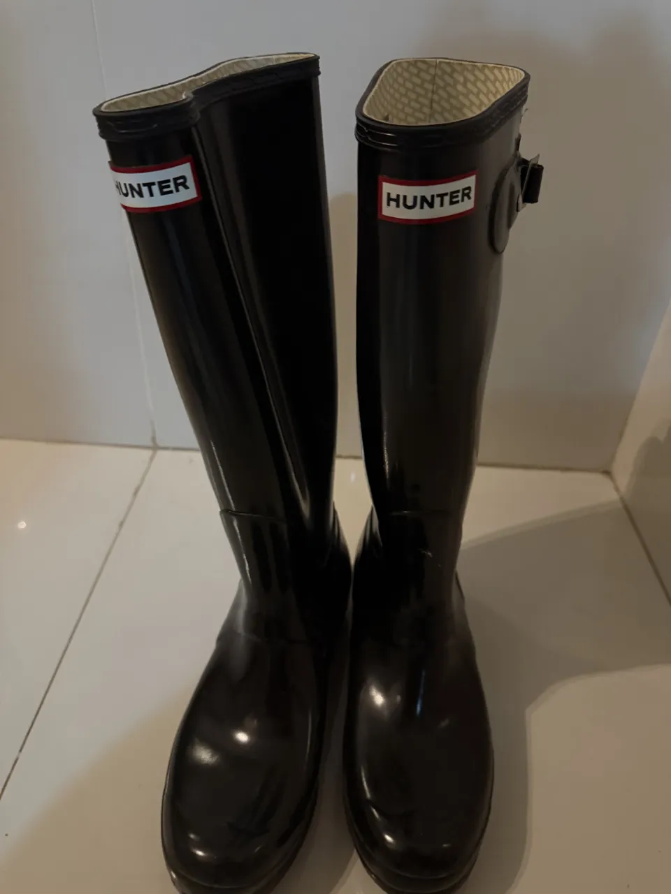 Botas de lluvia negras marca Hunter, ideales para días de lluvia o actividades al aire libre. Su diseño clásico y su material impermeable las hacen perfectas para mantener tus pies secos y protegidos.