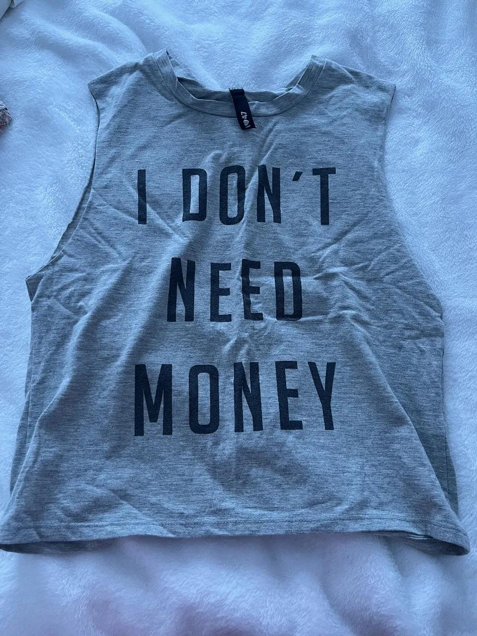 Musculosa de mujer gris con estampado "I don't need money" y "Money needs me". Ideal para un look casual y canchero.