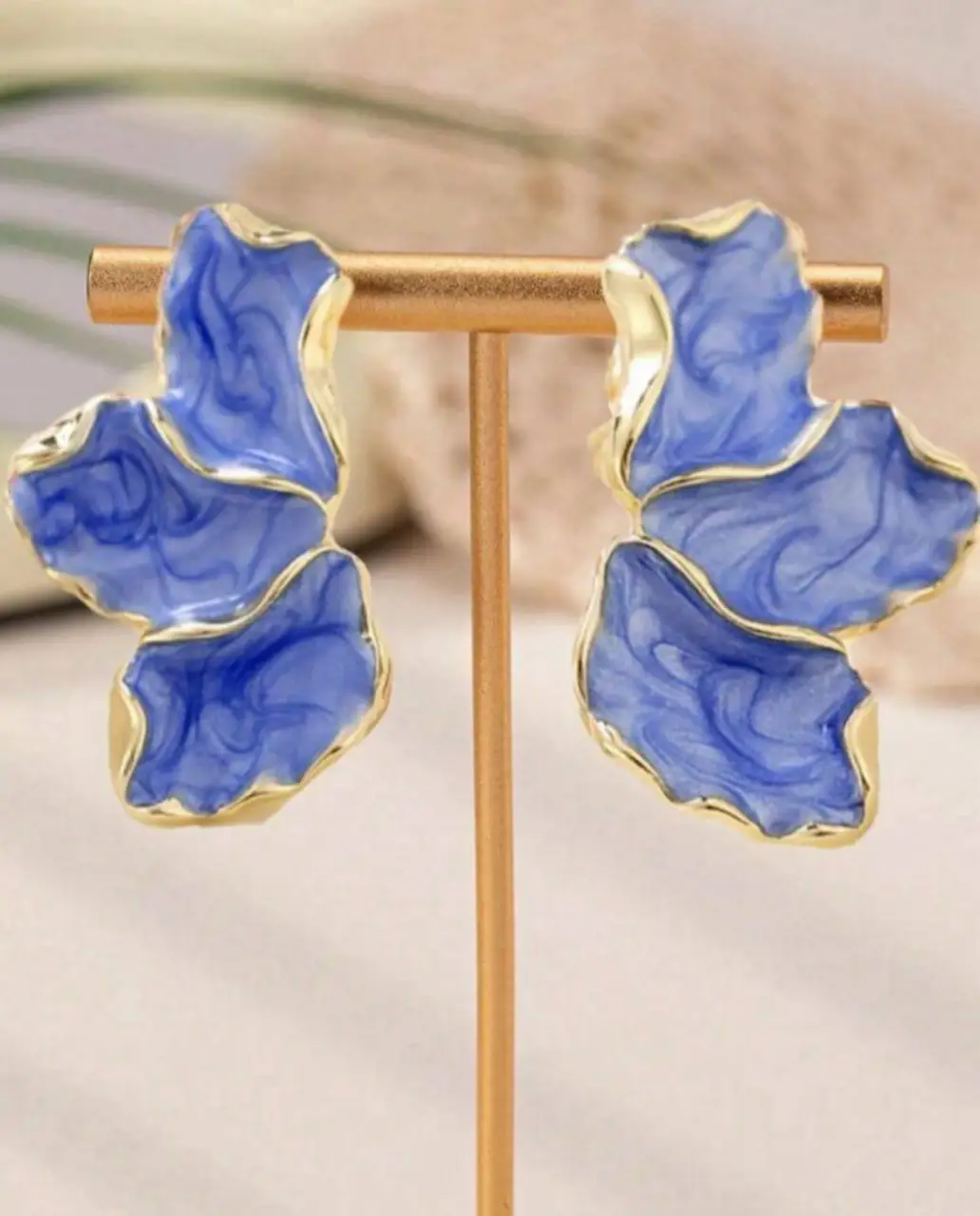 Aros de diseño floral en tonos azules con detalles dorados. Ideales para darle un toque de color y sofisticación a cualquier look.