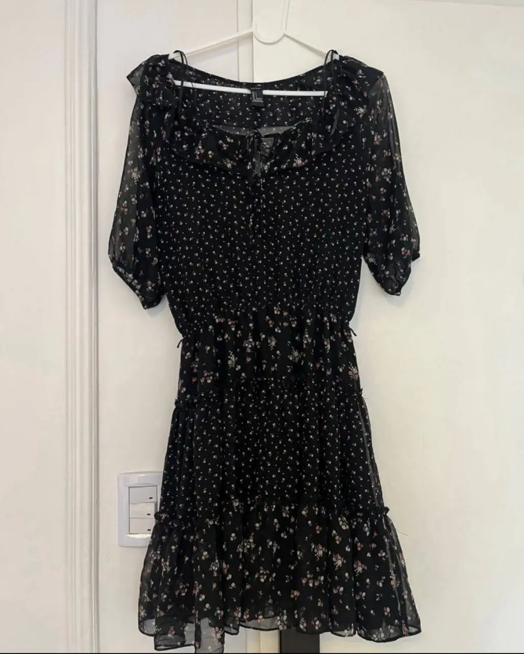 Vestido mini negro con estampado floral, ideal para un look casual y fresco. Confeccionado en tela ligera y detalles de volantes. tipo gasa