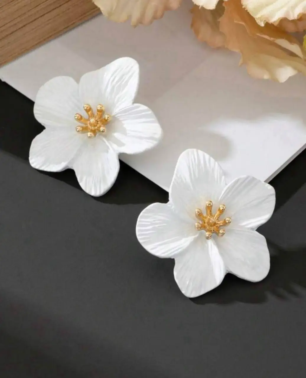 Hermosos aros de flores blancas con centro dorado, ideales para darle un toque fresco y femenino a cualquier look. Perfectos para un evento especial o para el día a día.