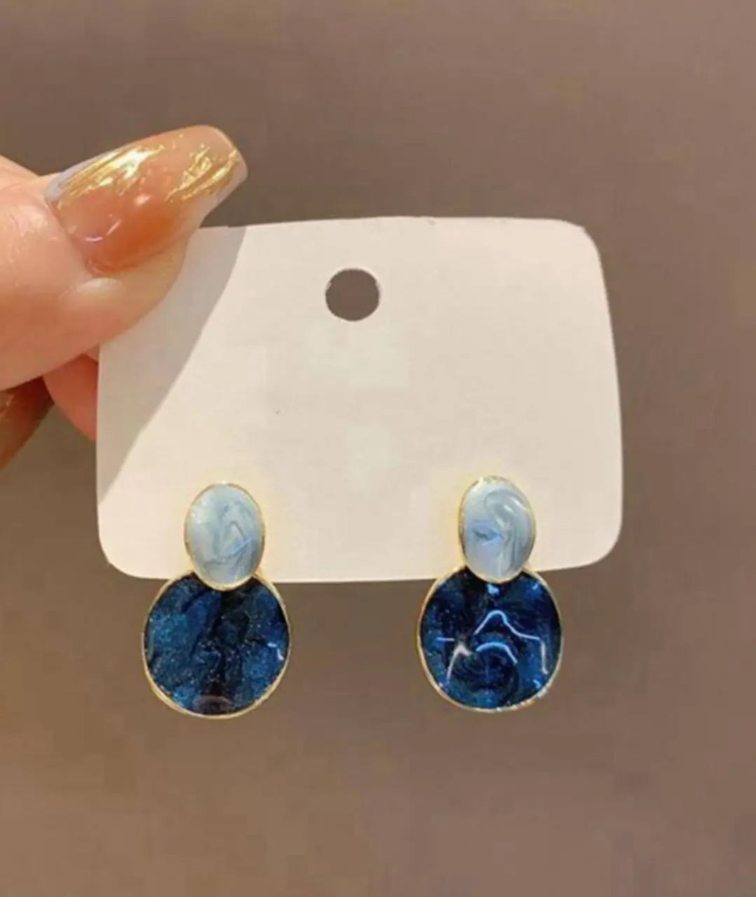Hermosos aros colgantes con diseño de círculos en tonos azulados y detalles dorados. Perfectos para darle un toque de elegancia a cualquier look.