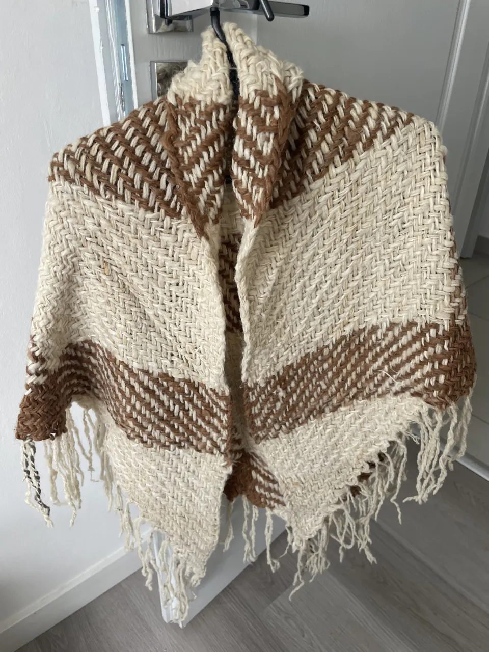 Poncho tejido a mano con flecos. Diseño a rayas en dos tonos.