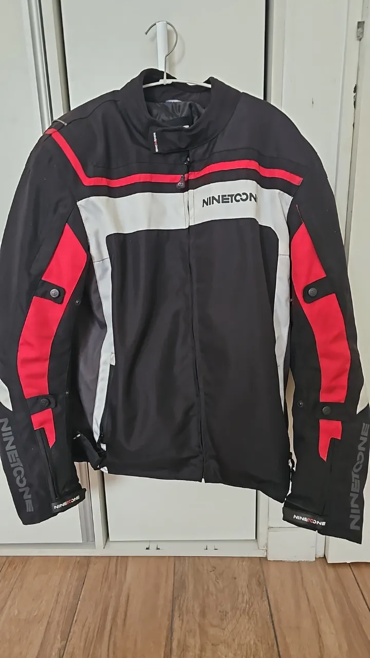 Chaqueta de MOTO Nine to One, negra con detalles en rojo y blanco. Ideal para protegerte y lucir un estilo deportivo y moderno.