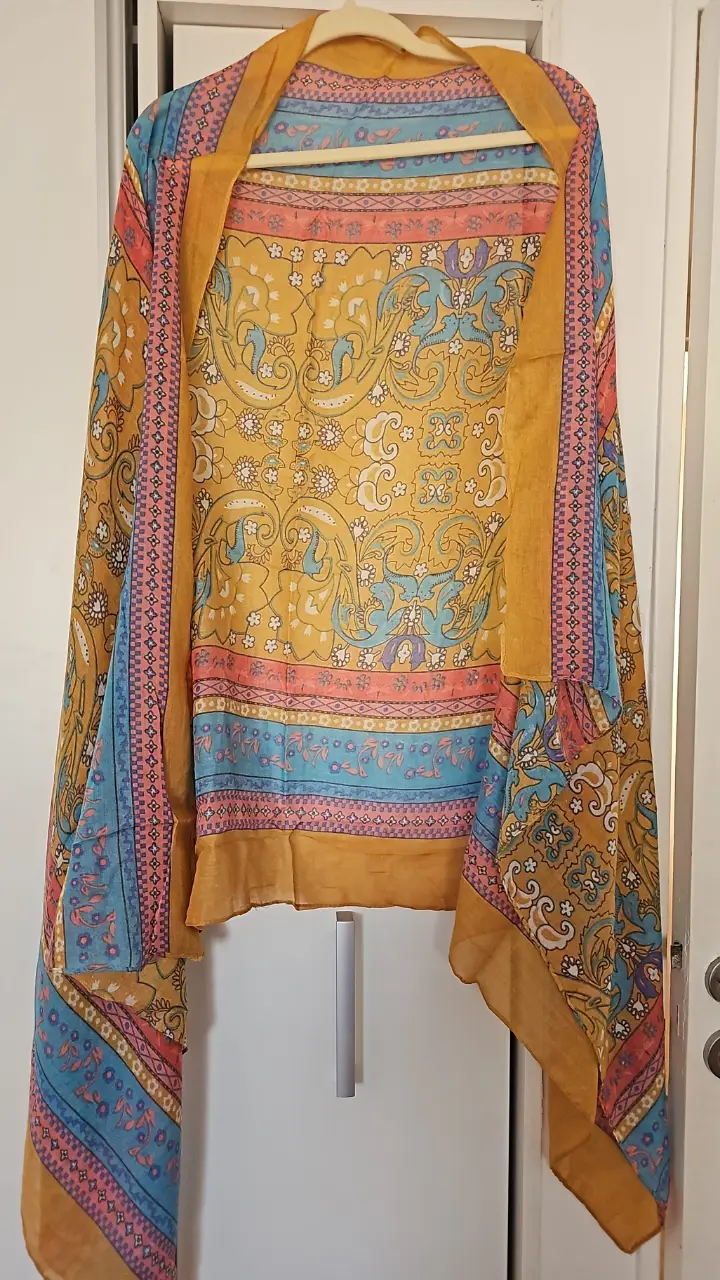 Pashmina con estampado floral en tonos amarillos, azules y rosas. Ideal para un look bohemio y elegante.