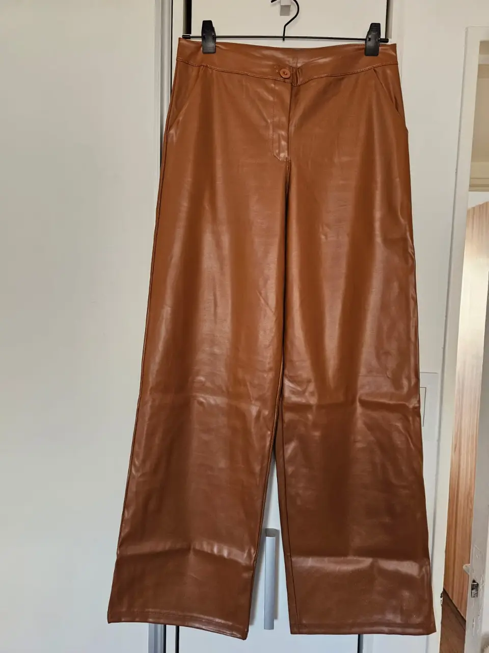 Pantalón sastrero de cuero sintético color marrón. Tiro alto, corte ancho y elegante. Ideal para un look sofisticado y moderno. cintura 39cm cadera 50cm tiro delantero 30cm tiro trasero 36cm largo 105cm Pu 100%