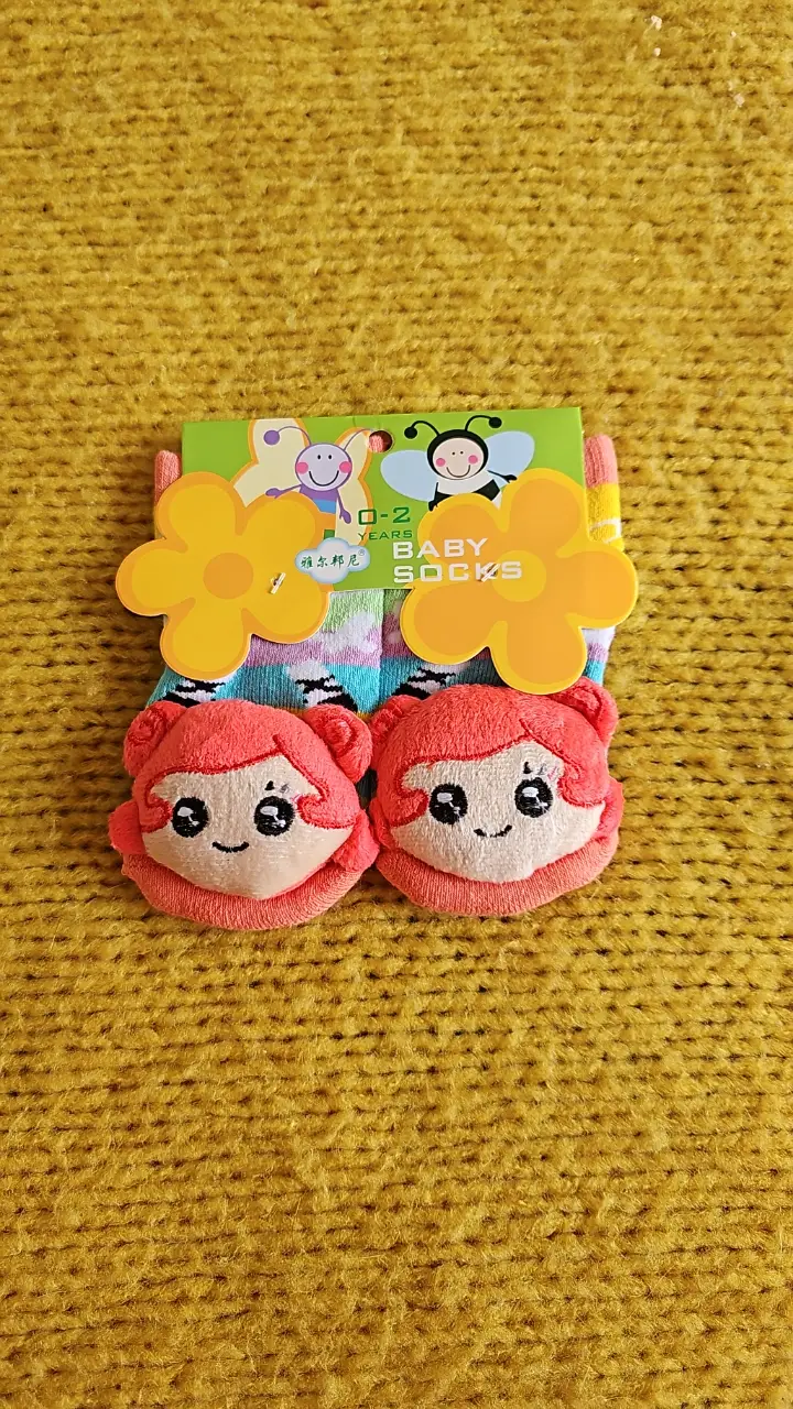 Lindos zoquetes para bebés de 0 a 2 años. Diseño con caritas de niña y detalles de flores. Ideales para mantener los pies de tu bebé abrigados y cómodos. con muñequito en la puntera y un cascabel imterno