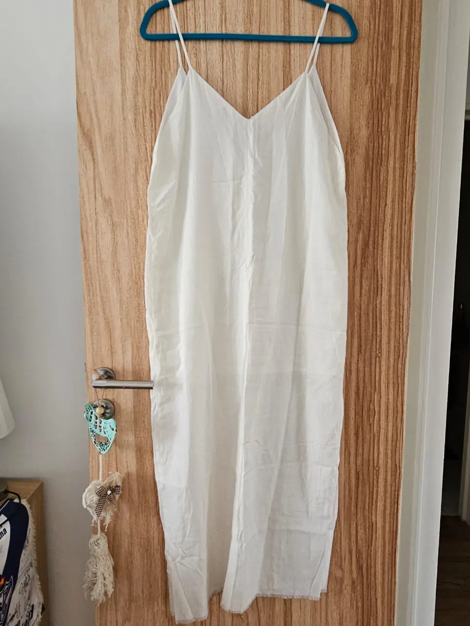 Vestido largo blanco con tirantes finos y escote en V. Ideal para el verano, este vestido de lino es fresco y cómodo, perfecto para un look casual y relajado. sisa 45cm, cintura 49 cm, cadera 52cm, tajo 43cm, largo total ver fotos