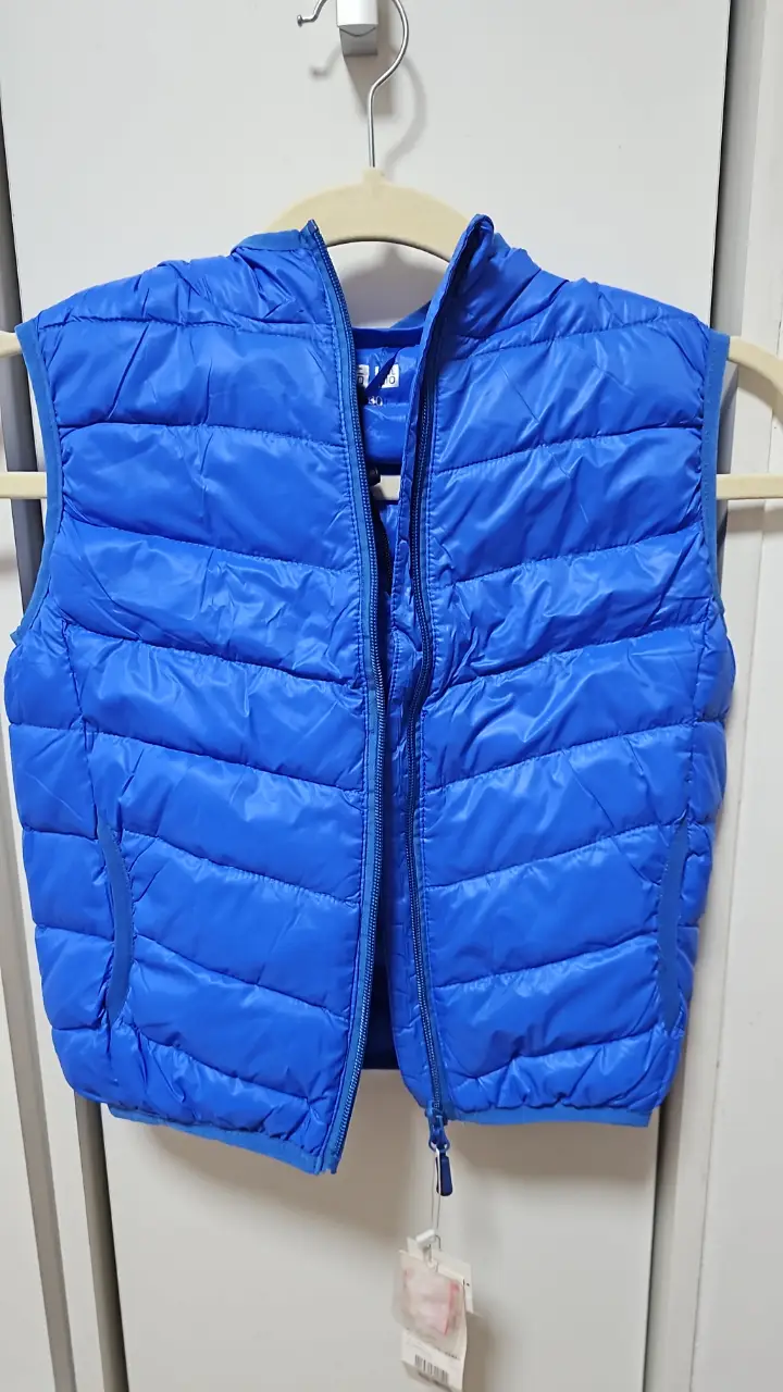 Chaleco inflable azul para niño, con capucha y cierre. Ideal para abrigo ligero y cómodo.