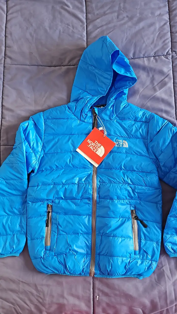Campera de pluma azul para niño, ideal para el invierno. Cuenta con capucha y cierre frontal. Perfecta para mantener a los más pequeños abrigados y cómodos. FIJARSE BIEN LAS MEDIDAS. hombro 36cm axila a axila 39cm, largo manda 51cm , largoo total 51 cm.