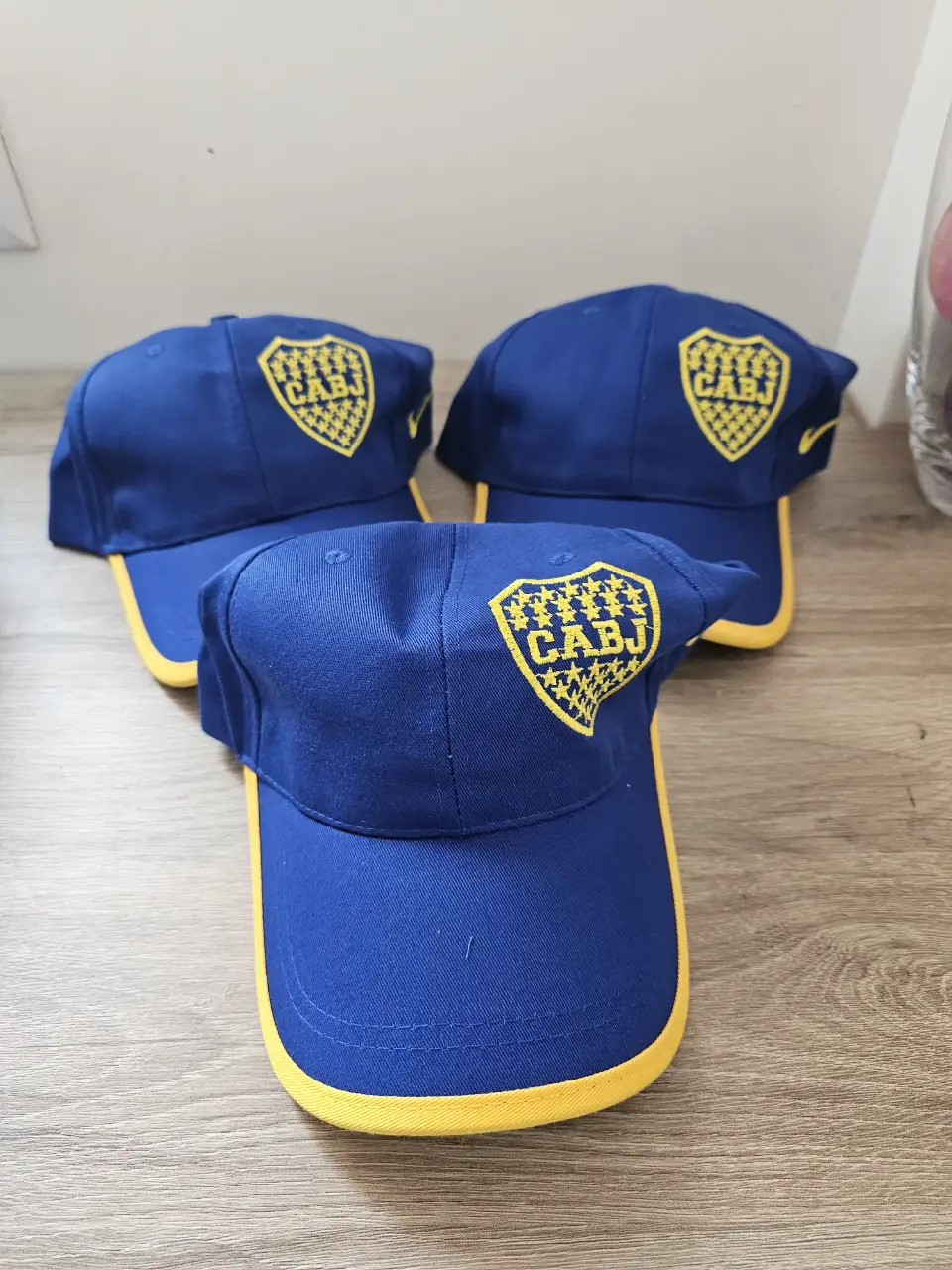TRES Gorras de Boca Juniors, color azul con visera amarilla y el escudo del club bordado en la parte frontal. Ideal para fanáticos del fútbol y para usar en eventos deportivos o salidas casuales.