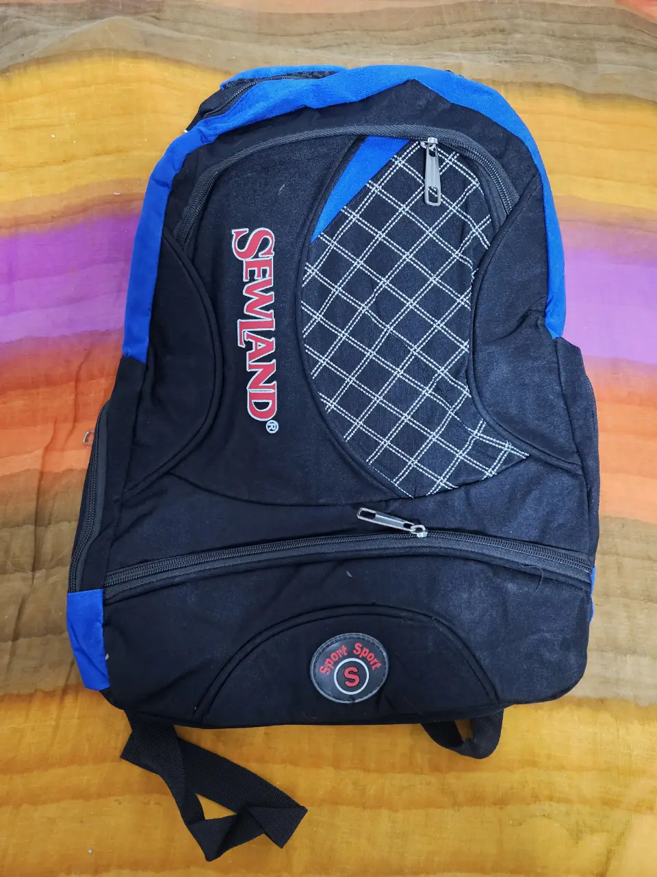 Mochila deportiva negra y azul con detalles en blanco. Ideal para llevar tus cosas al gimnasio o para el día a día. Cuenta con varios compartimentos y cierres.