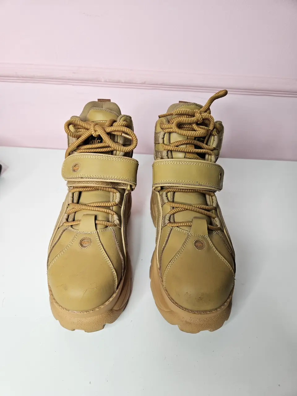 zapatillas con plataforma de cuero sintético color marrón claro, con cordones y ajuste de velcro. Suela gruesa y diseño robusto, ideales para un look urbano y moderno.