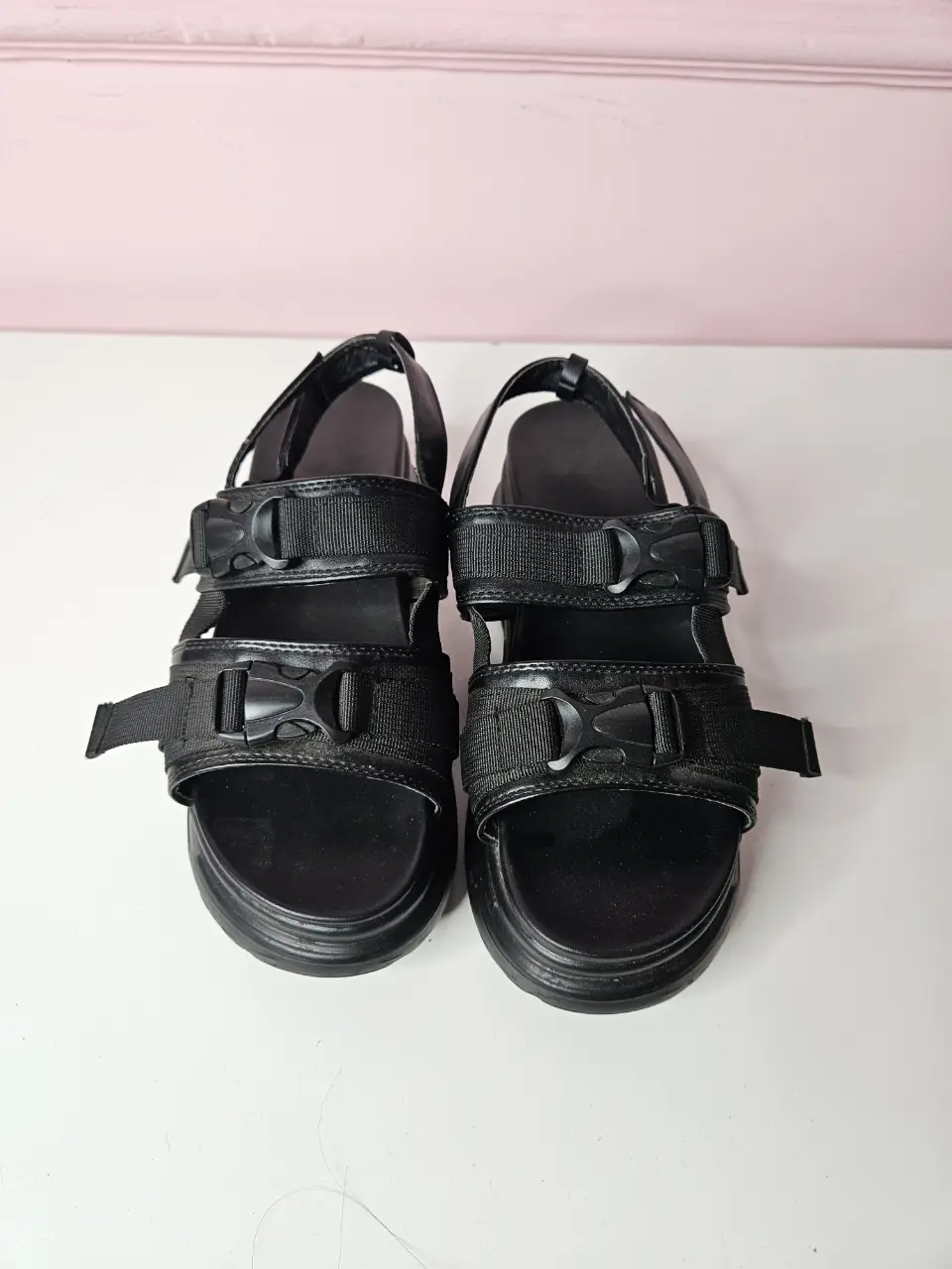 Sandalias negras con hebillas y plataforma, ideales para un look urbano y moderno. Perfectas para combinar con diferentes outfits.