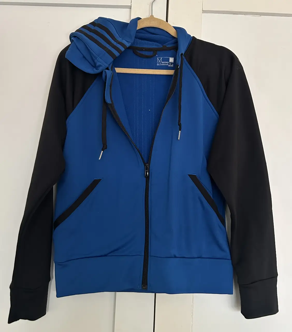 Buzo con cierre Adidas, azul con mangas y detalles en negro. Ideal para actividades deportivas o uso casual. Talle M.