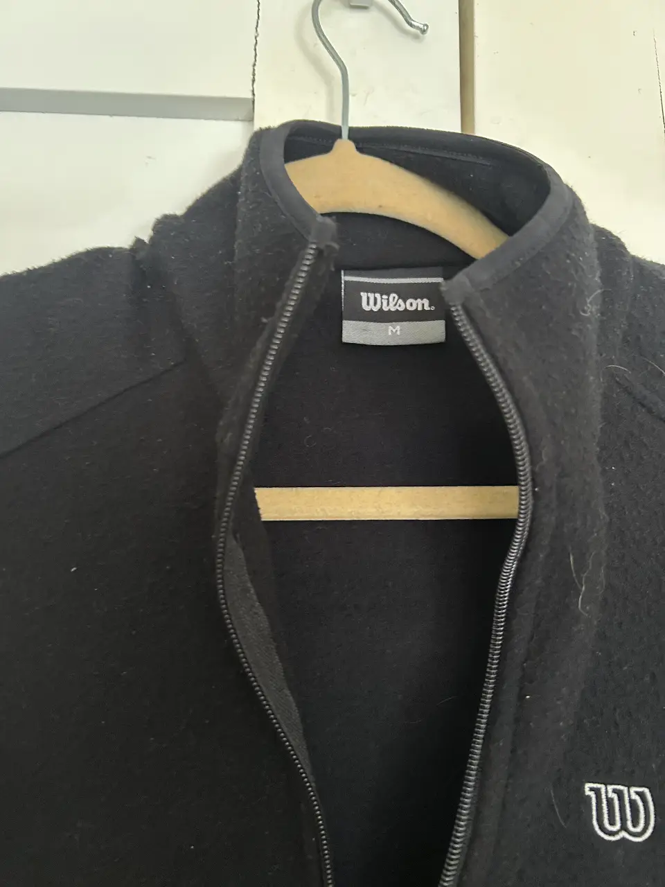 Campera polar deportiva negro de mujer con cierre y logo Wilson. Ideal para actividades deportivas o uso casual. Talle M chico