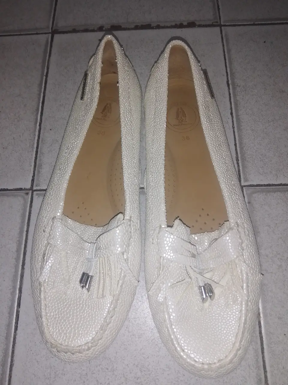 Mocasines Hush Puppies número 38 blancos de mujer, con detalle de lazo y borlas. Ideales para un look casual y cómodo.