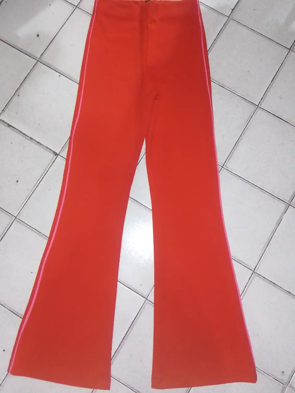 Pantalón ST Marie rojo de mujer, estilo campana con detalle de línea rosa en los laterales. Ideal para un look casual y moderno.