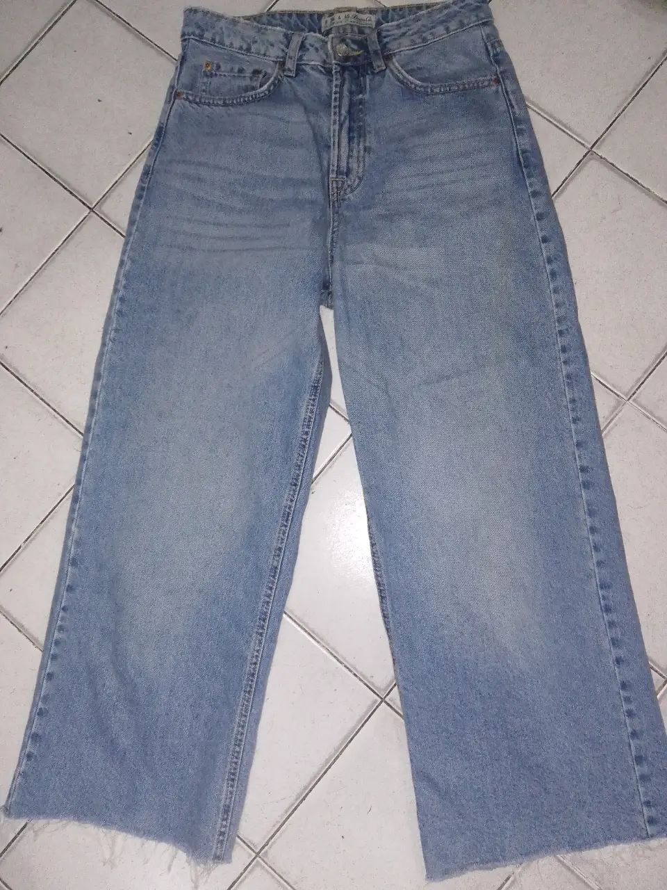 Jeans rectos de mujer, tiro alto, con un corte recto y un ligero efecto desgastado. Ideal para un look casual y moderno.
