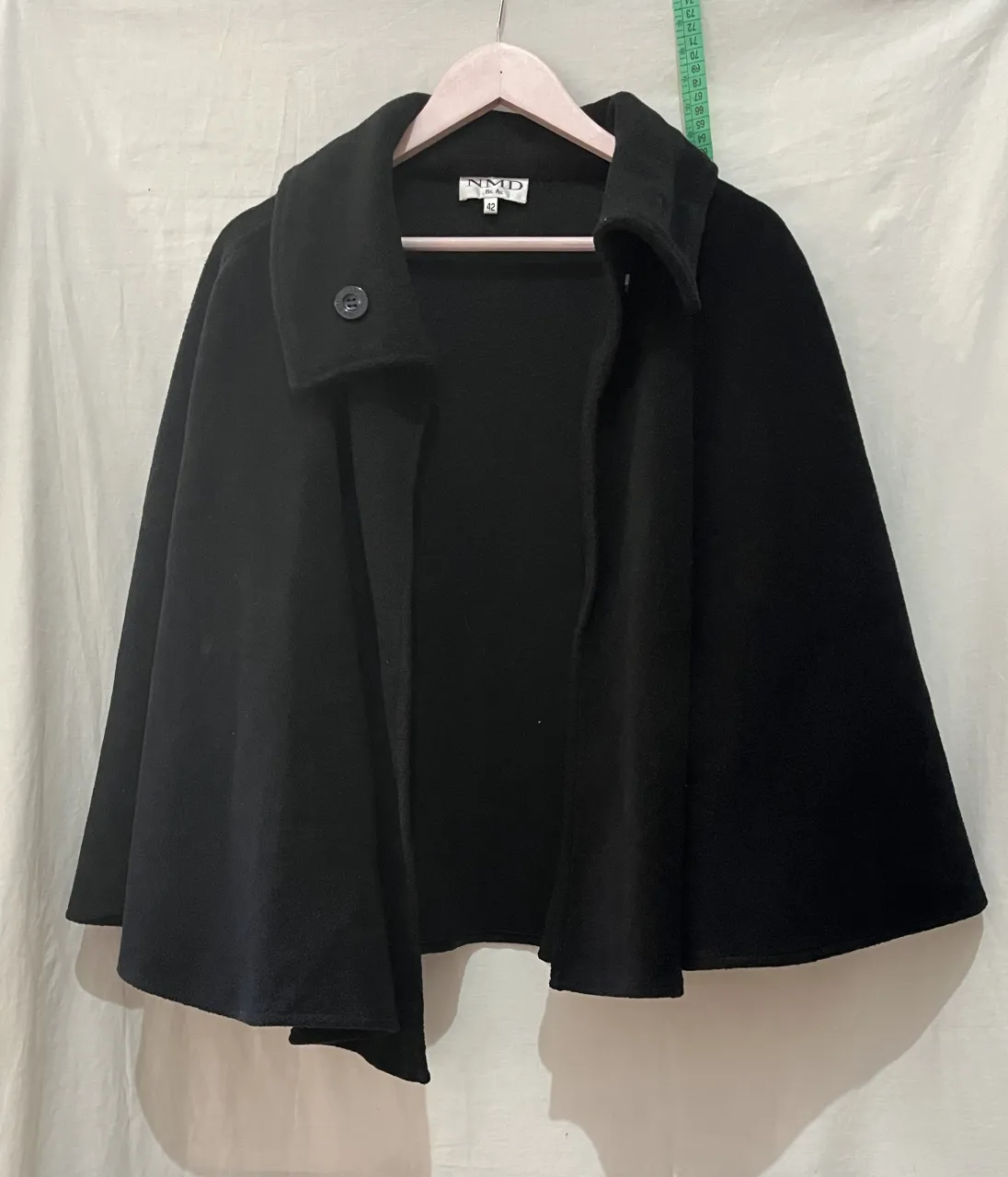 Poncho negro con un botón al frente y cuello alto. talle 42