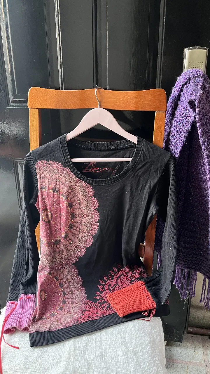 Remera manga larga negra con detalles en rosa y estampado en el frente. Puños y detalles en rosa.naranja detalles bordados en hilo dorado  Diseño Desigual. 