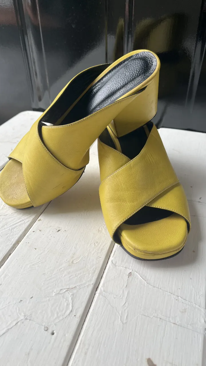 Sandalias de cuero amarillas con taco cuadrado. Diseño con tiras cruzadas en la parte delantera y plantilla negra. Ideales para un look moderno y cómodo. (( detalles de uso nada más )) Argentina 