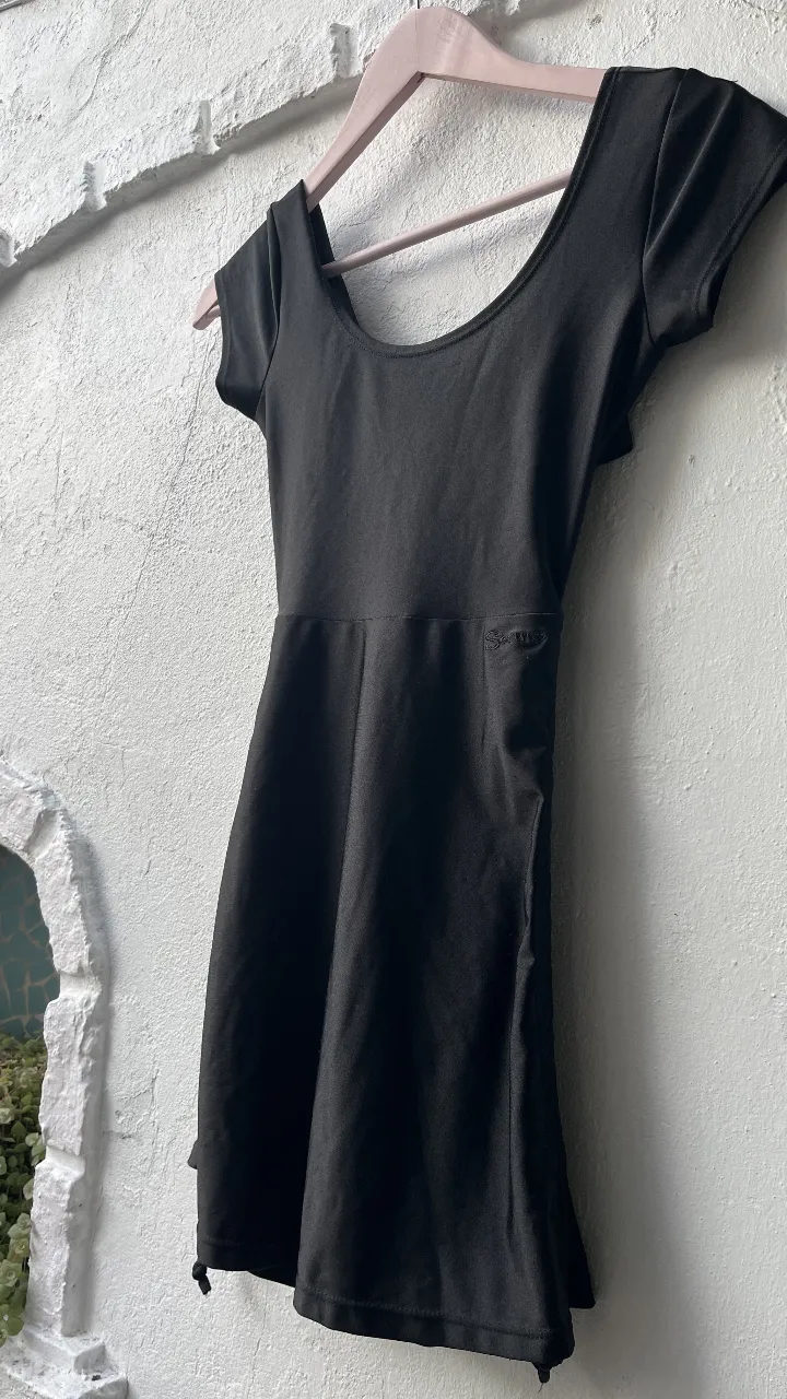 Vestido negro corto, con mangas cortas y escote en la espalda. Ideal para una salida.