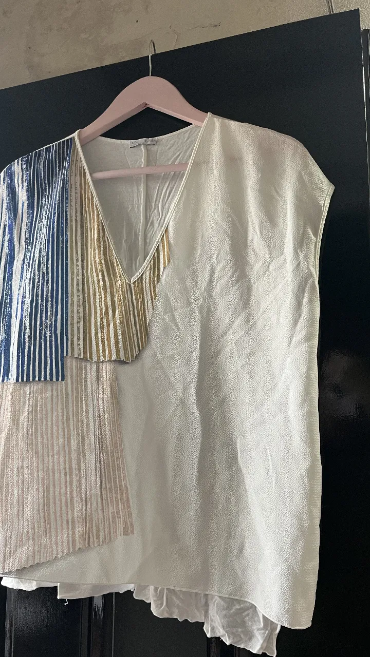 Blusa de mujer con diseño patchwork, combinando paneles en blanco liso, rayas verticales en tonos dorados y beige, y bloques con rayas azules y blancas. Cuello en V y corte holgado, ideal para un look casual y fresco.

made in Portugal 
talla RUR M /MEX 26