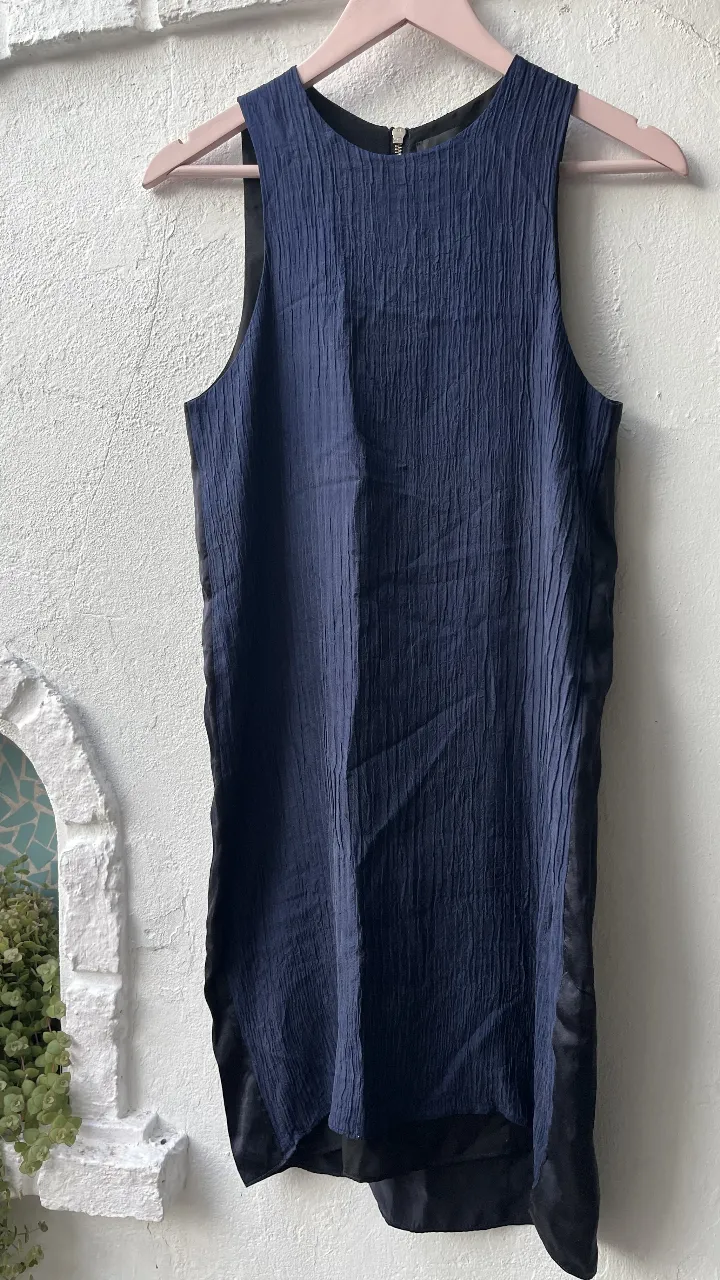 Vestido mini de mujer, sin mangas, con textura en la parte superior y detalles en negro liso en los laterales y la parte inferior. Cierre en la espalda.
talle en su etiqueta dice 40 